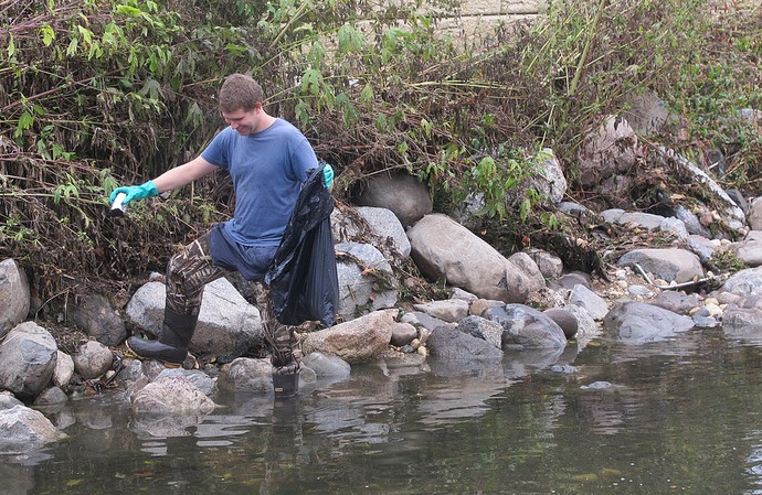 Kyle Puckhaber helped remove trash from the Kinnickinnic River during a clean-up event. (Photo by Scottie Lee Meyers)